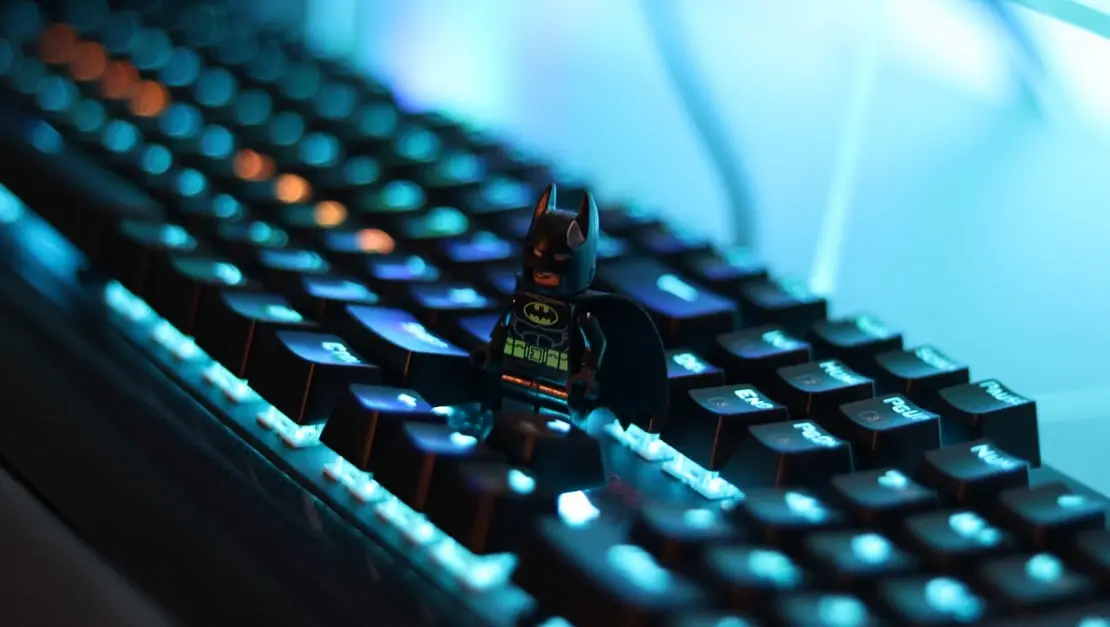 Backlit gaming keyboard with a figurine, representing esports and competitive gaming culture.
