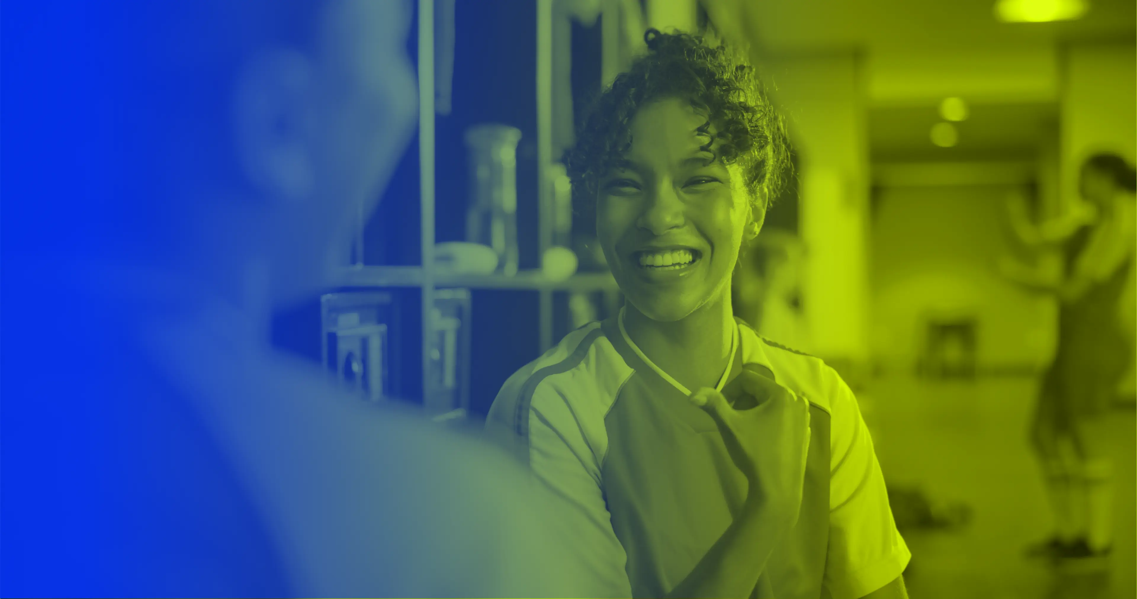 Women athletes talking and smiling in a locker room, representing communication and partnership in sports organizations.