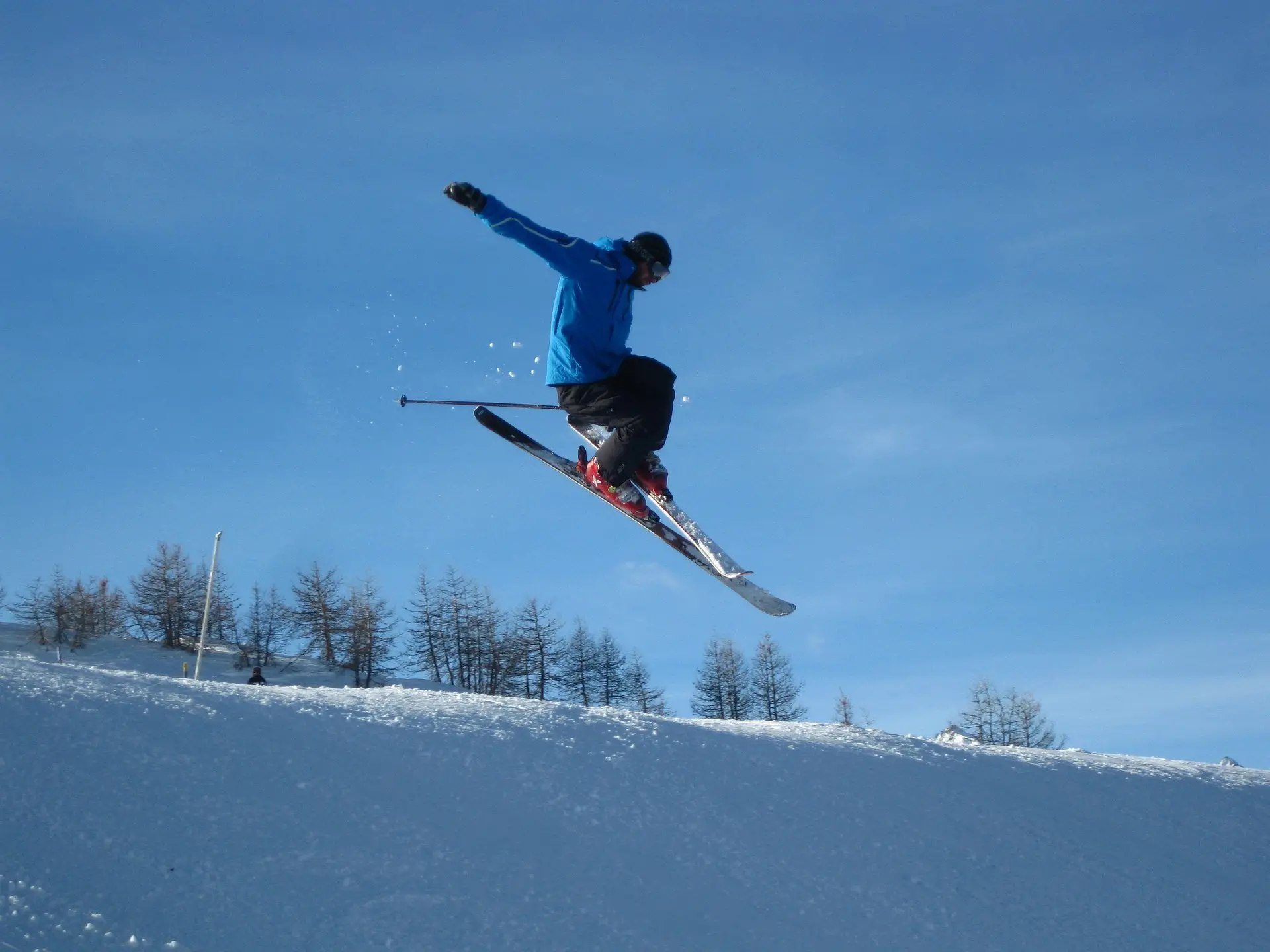 Skier mid-air during a jump, representing how modern equipment and materials improve Winter Olympics performance.